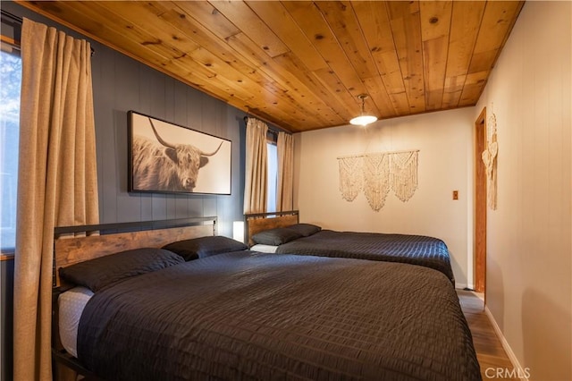 bedroom with wood-type flooring, wood ceiling, and wooden walls