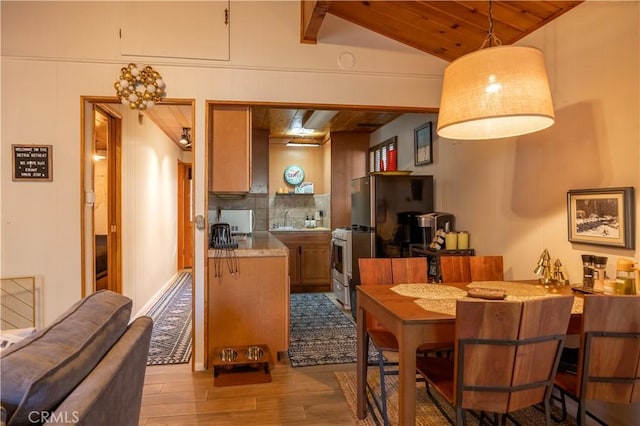 kitchen with sink, hanging light fixtures, wooden ceiling, lofted ceiling, and light wood-type flooring