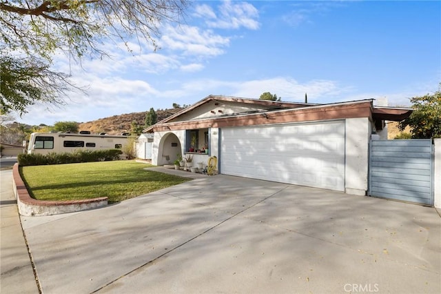 view of front of house with a mountain view, a front lawn, and a garage