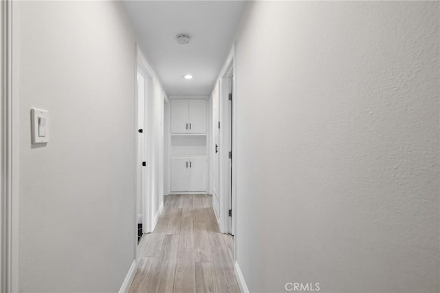 hallway with light hardwood / wood-style floors