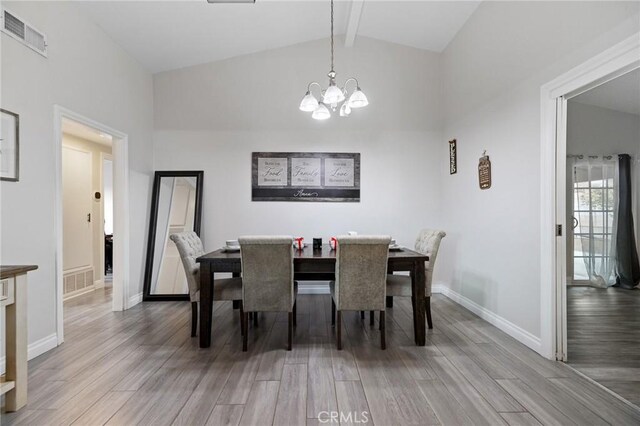 dining space with a chandelier, lofted ceiling with beams, and light hardwood / wood-style flooring