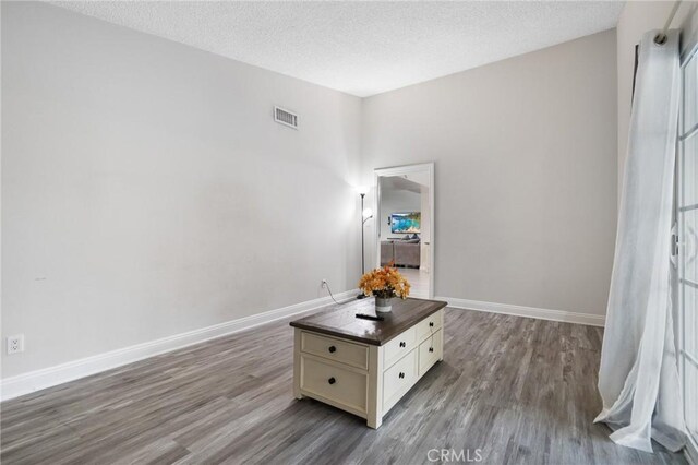 interior space with a textured ceiling and hardwood / wood-style flooring