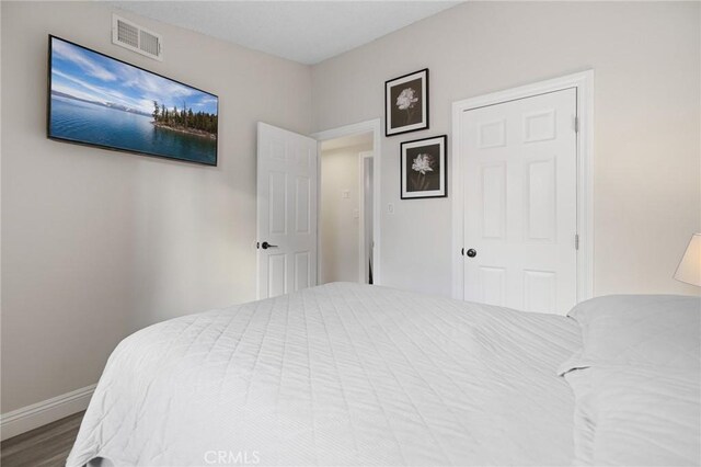 bedroom with wood-type flooring and a closet