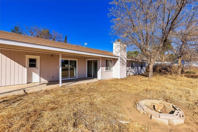 back of property with a patio area and a fire pit