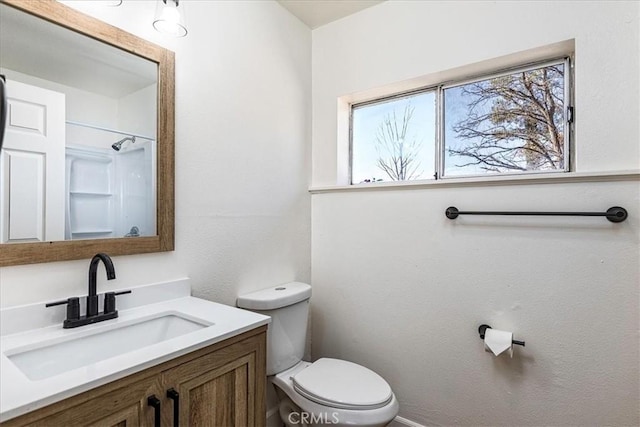 bathroom featuring vanity, toilet, and a healthy amount of sunlight