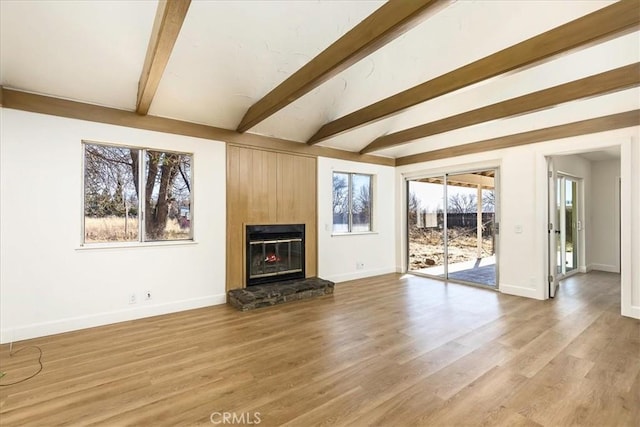 unfurnished living room with light wood-type flooring and lofted ceiling with beams