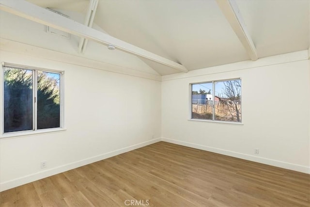 empty room with hardwood / wood-style floors and lofted ceiling with beams