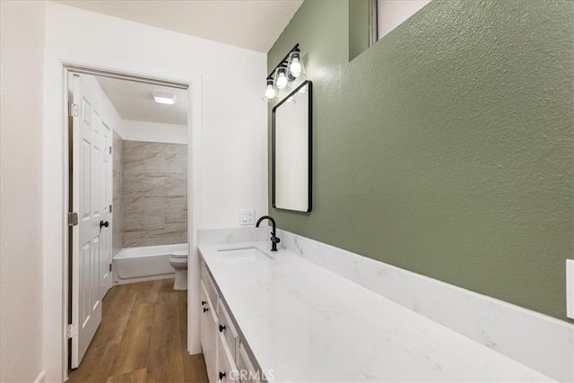 full bathroom with vanity, toilet, wood-type flooring, and tiled shower / bath combo