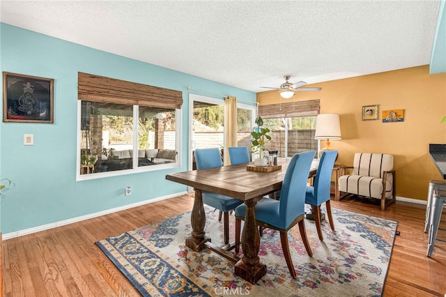 dining space featuring ceiling fan, wood-type flooring, and a textured ceiling