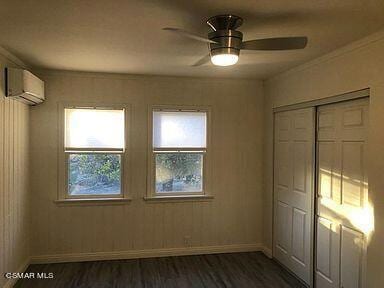 spare room with ceiling fan, dark hardwood / wood-style flooring, a wall mounted air conditioner, and ornamental molding