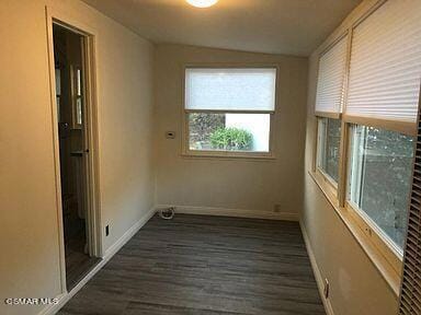 unfurnished room featuring dark hardwood / wood-style flooring and vaulted ceiling