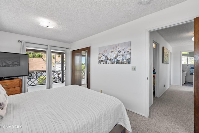 bedroom with access to exterior, light colored carpet, and a textured ceiling