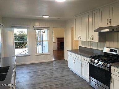 kitchen featuring dark hardwood / wood-style flooring, white cabinetry, and stainless steel range with gas stovetop