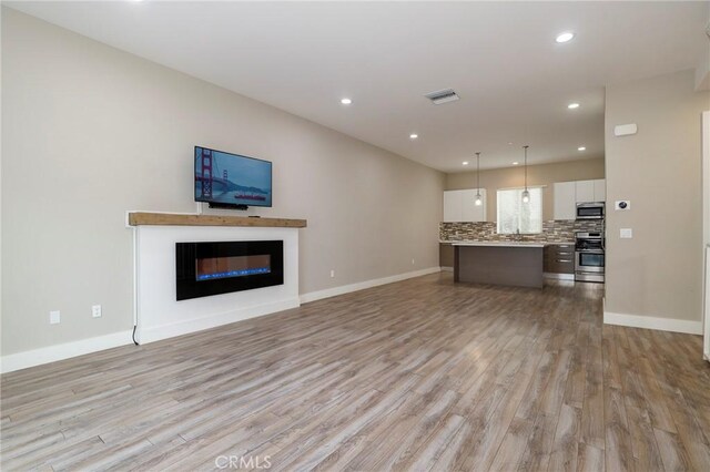 unfurnished living room featuring light wood-type flooring