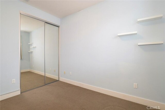 unfurnished bedroom featuring carpet flooring and a closet