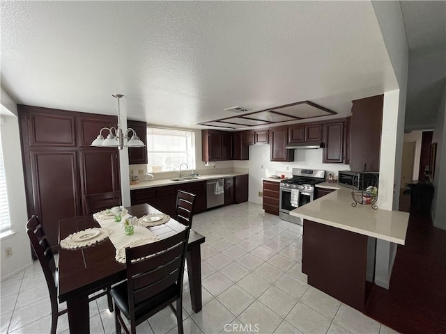 kitchen with pendant lighting, sink, stainless steel appliances, light tile patterned floors, and a chandelier