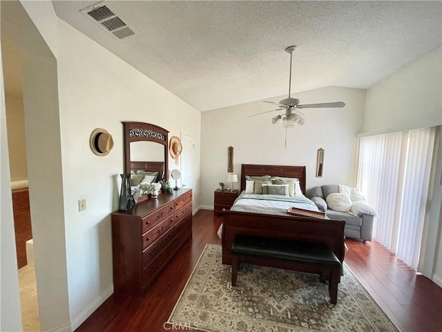 bedroom with ceiling fan, a textured ceiling, dark hardwood / wood-style floors, and vaulted ceiling