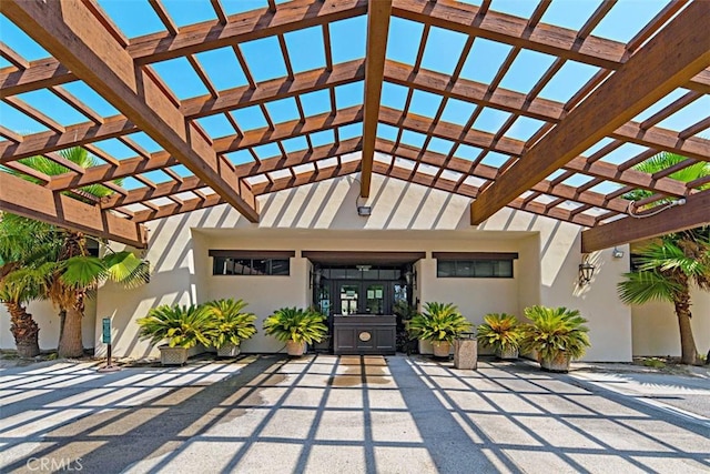 view of exterior entry with a pergola