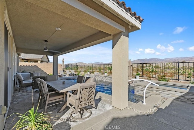 view of patio with ceiling fan and a mountain view