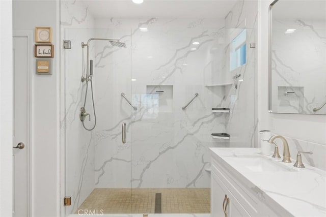 bathroom with vanity and a shower with door