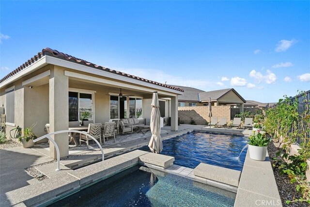 view of swimming pool with an outdoor living space, a patio, and pool water feature