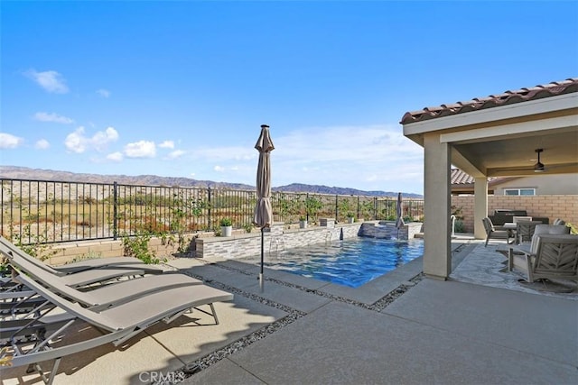 view of pool featuring ceiling fan, a mountain view, and a patio area