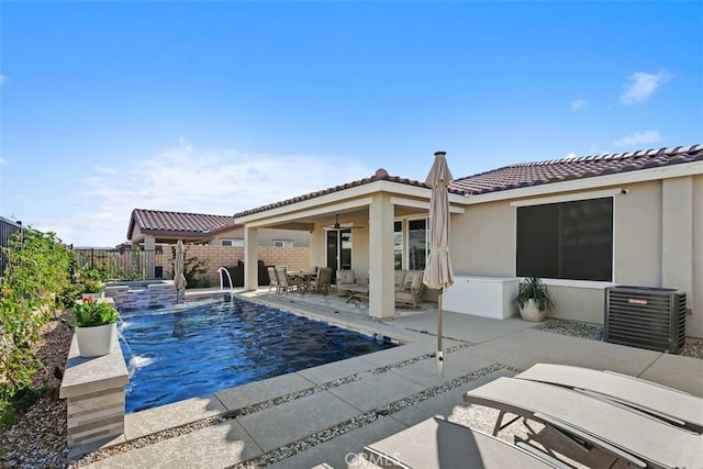 view of pool featuring pool water feature, cooling unit, and a patio area