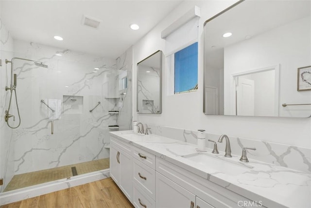 bathroom featuring wood-type flooring, an enclosed shower, and vanity