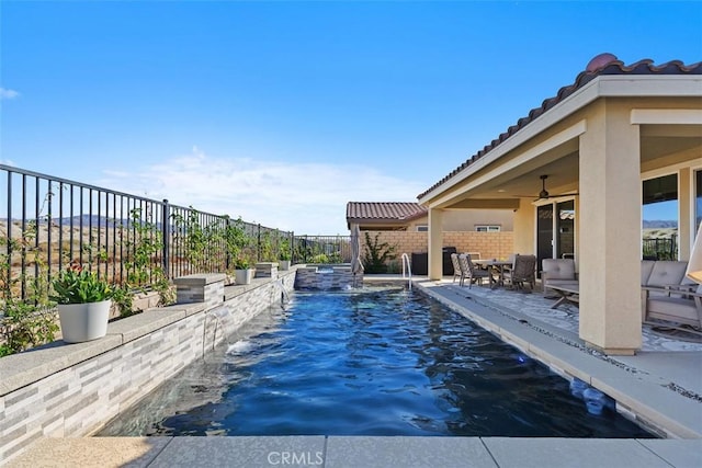 view of pool featuring pool water feature, a patio, and ceiling fan