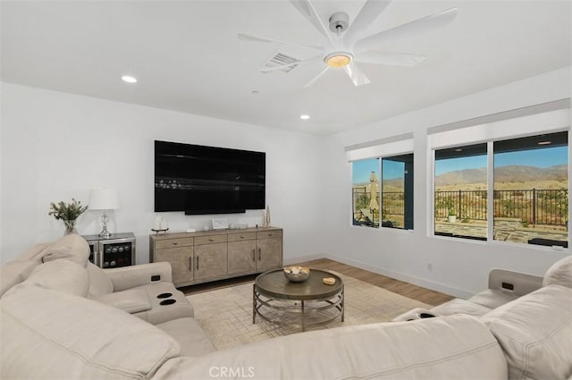 living room featuring ceiling fan and light hardwood / wood-style floors