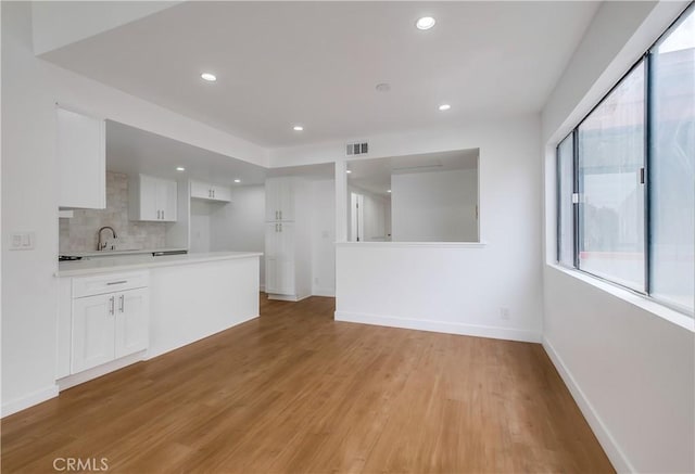 unfurnished living room featuring a wealth of natural light and light hardwood / wood-style flooring