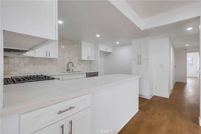 kitchen with white cabinetry, sink, dark hardwood / wood-style floors, decorative backsplash, and appliances with stainless steel finishes