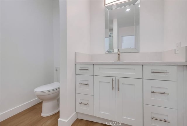 bathroom with vanity, hardwood / wood-style flooring, and toilet