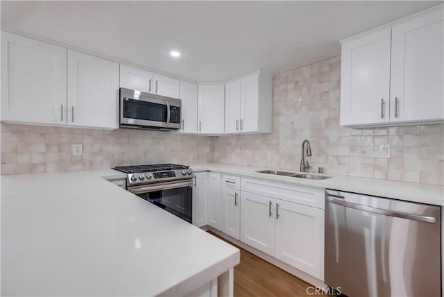 kitchen featuring white cabinetry, sink, hardwood / wood-style floors, and appliances with stainless steel finishes