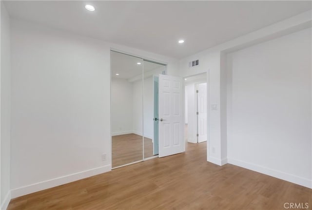 unfurnished bedroom featuring wood-type flooring and a closet