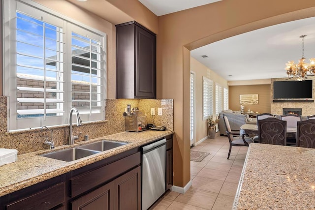 kitchen featuring stainless steel dishwasher, dark brown cabinetry, sink, and a wealth of natural light