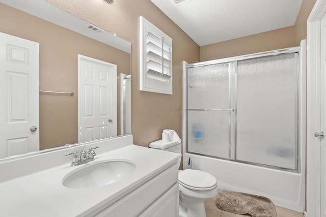 full bathroom featuring combined bath / shower with glass door, vanity, tile patterned floors, and toilet