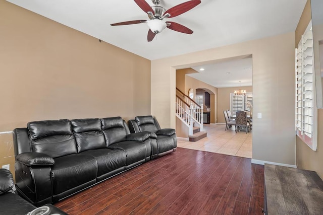 living room featuring wood-type flooring and ceiling fan with notable chandelier