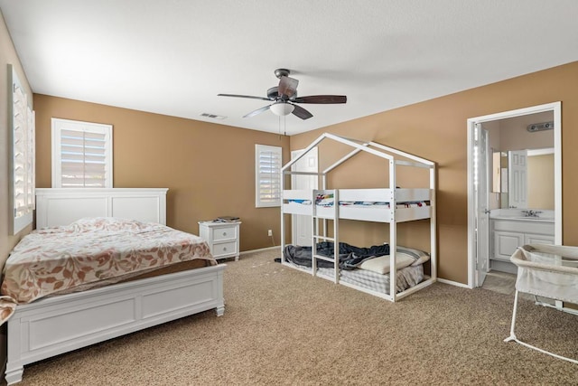 bedroom with carpet flooring, ceiling fan, and connected bathroom