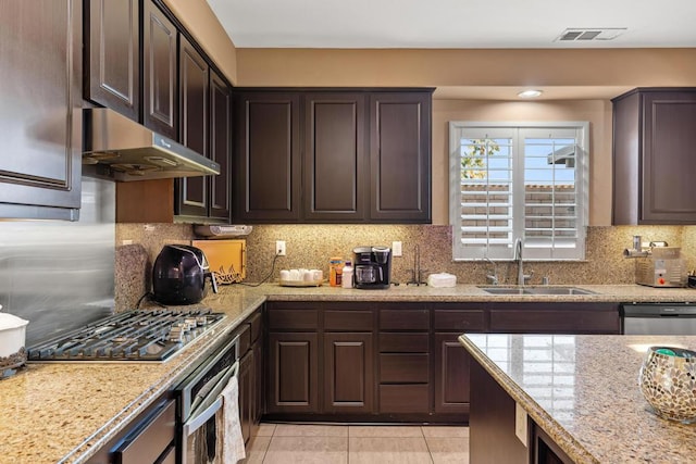 kitchen with backsplash, dark brown cabinetry, sink, and appliances with stainless steel finishes