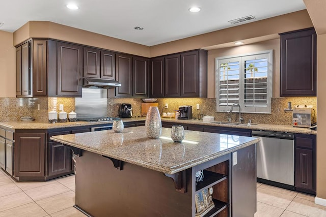 kitchen featuring a kitchen breakfast bar, dark brown cabinetry, a kitchen island, and appliances with stainless steel finishes