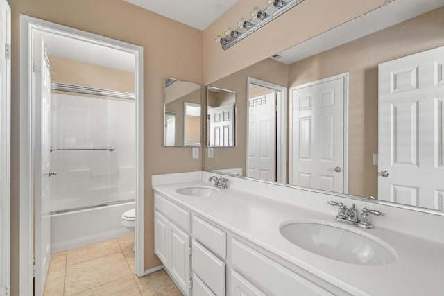 full bathroom featuring shower / bath combination with glass door, tile patterned flooring, vanity, and toilet