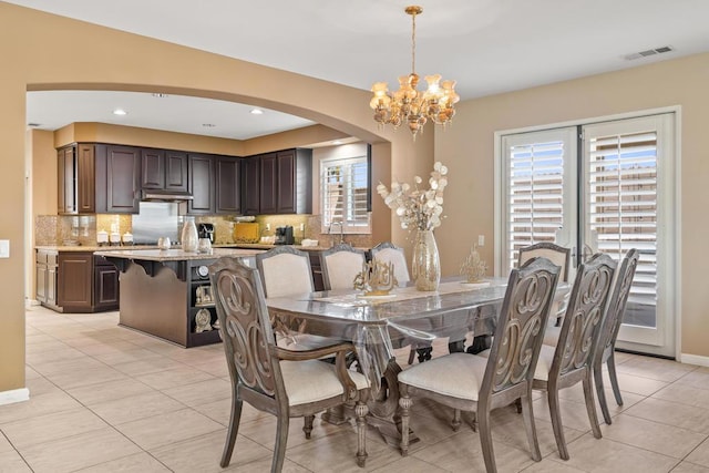 tiled dining room featuring a notable chandelier