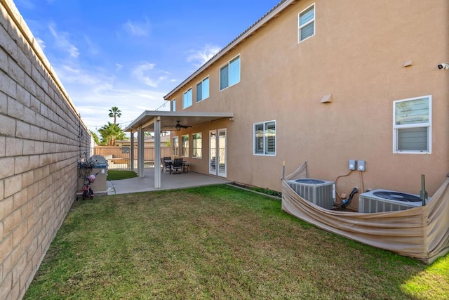 rear view of property with a lawn, ceiling fan, a patio area, and central air condition unit