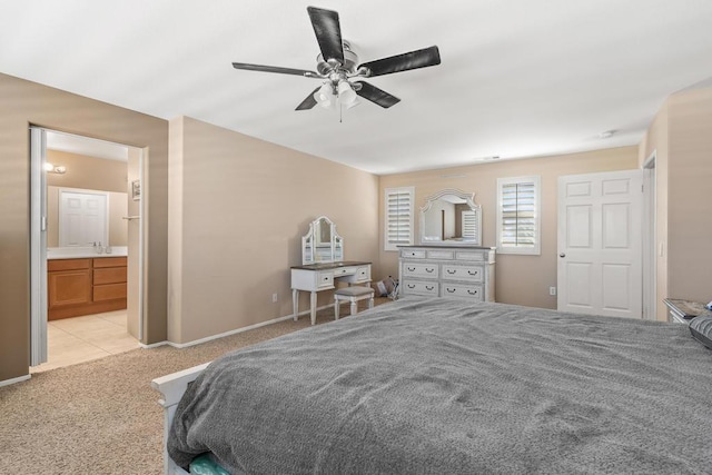 carpeted bedroom with ensuite bath and ceiling fan