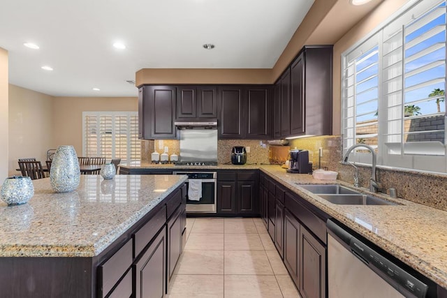 kitchen with light stone counters, sink, light tile patterned floors, and appliances with stainless steel finishes