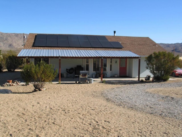 view of front of home featuring solar panels and a porch