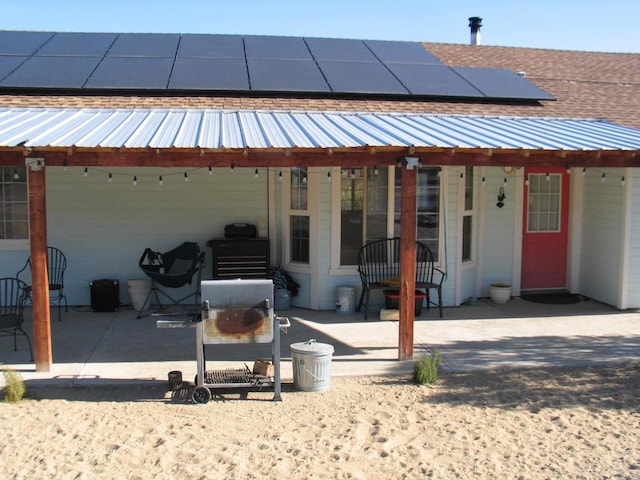 rear view of house with a patio and solar panels