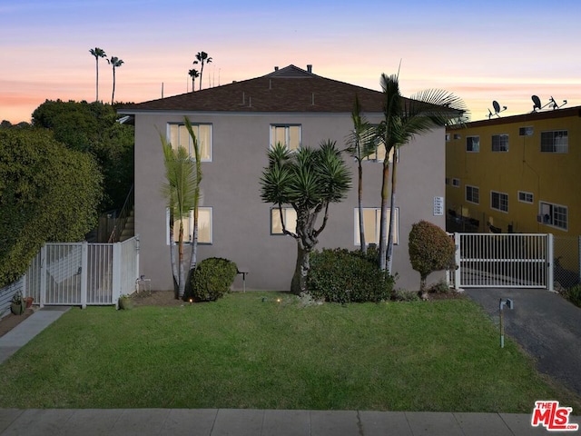 property exterior at dusk with a yard