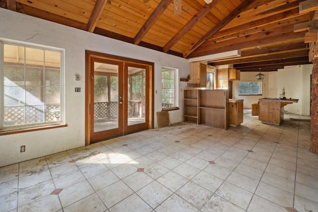 interior space featuring lofted ceiling with beams, wooden ceiling, light tile patterned floors, and french doors